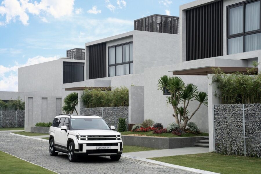 Hyundai Santa Fe màu trắng đỗ trước dãy nhà hiện đại