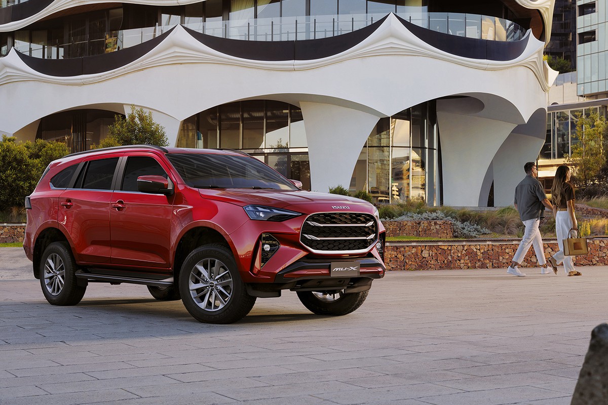 Isuzu MU-X màu đỏ trước công trình kiến trúc