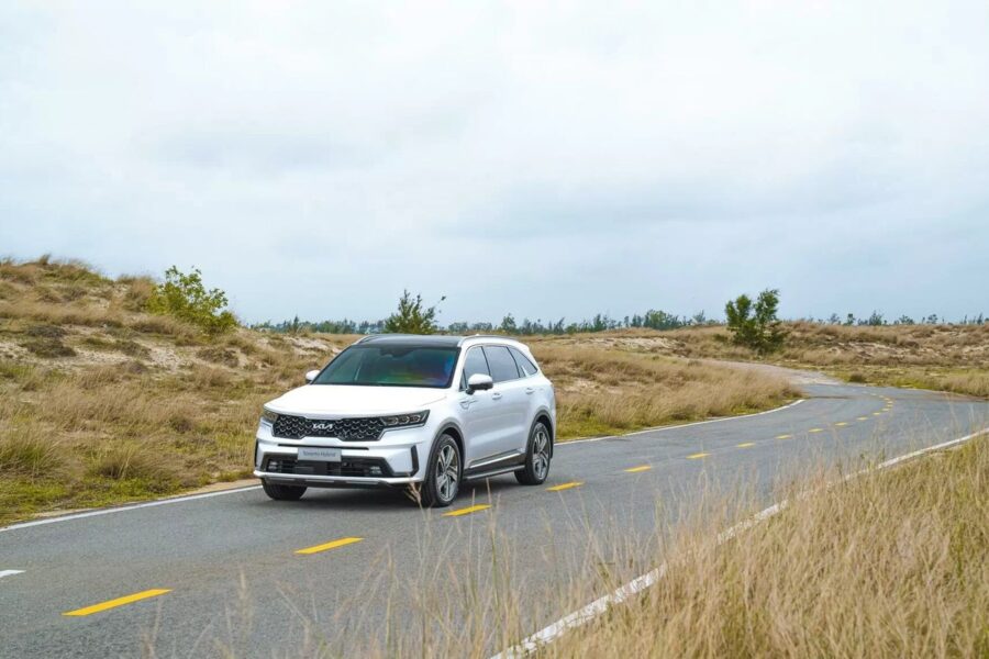 Sorento Hybrid màu trắng chạy trên đoạn đường cong